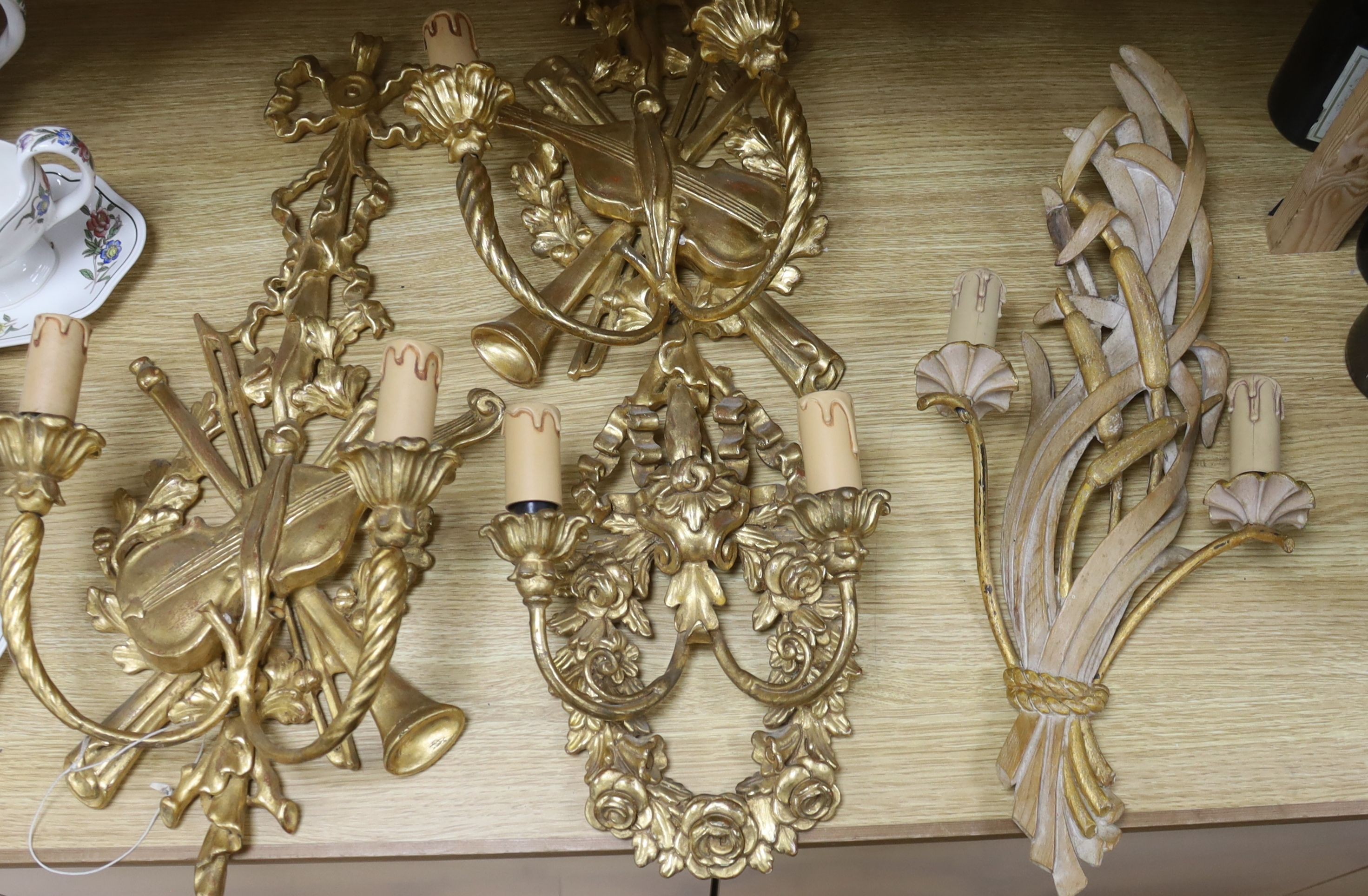 Two pairs of 18th century style Italian giltwood two branch wall lights and one other wall light, 62 cms high.